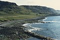 The coast south of Duntulm (1986) where barren high land is broken at lower level by farmable areas. The beach is bouldered. Housing is limited.